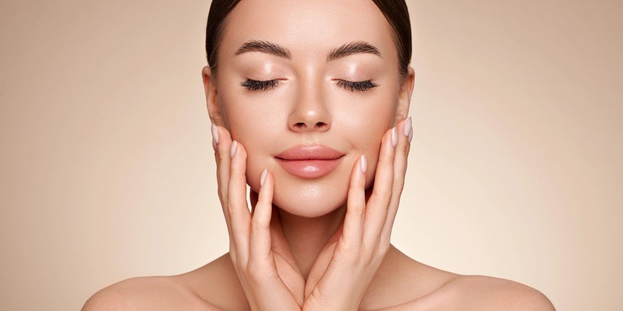 Close-up of a woman with flawless skin enjoying a skincare moment.