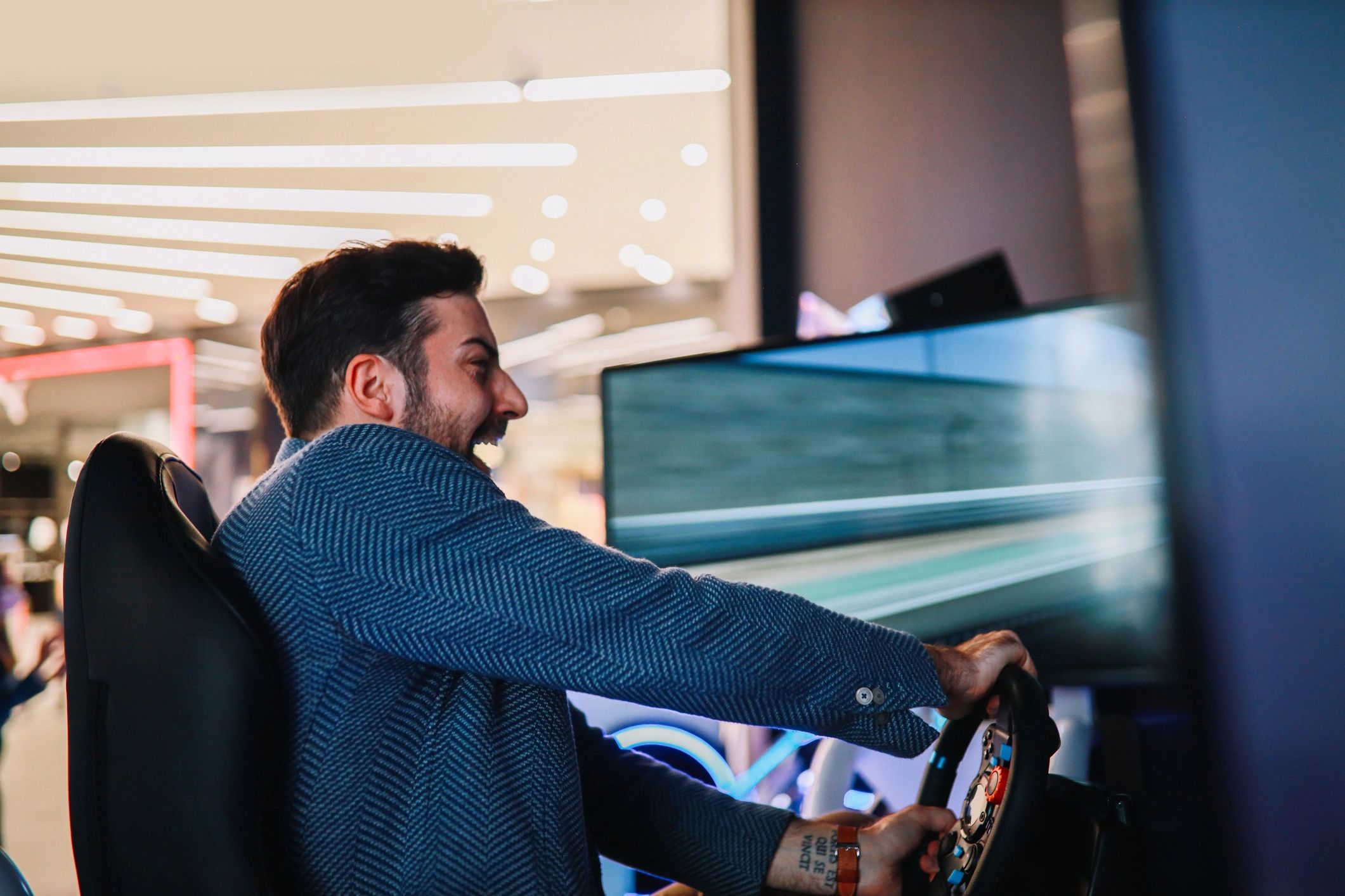 Man excitedly playing a racing video game on a simulator setup.
