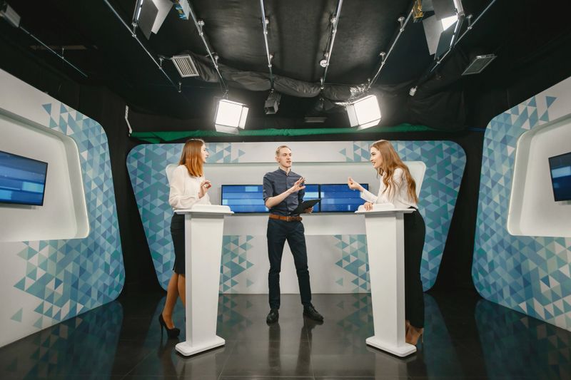 TV game show with two participants answering questions or solving puzzles and host. Smiling women participate in television quiz.