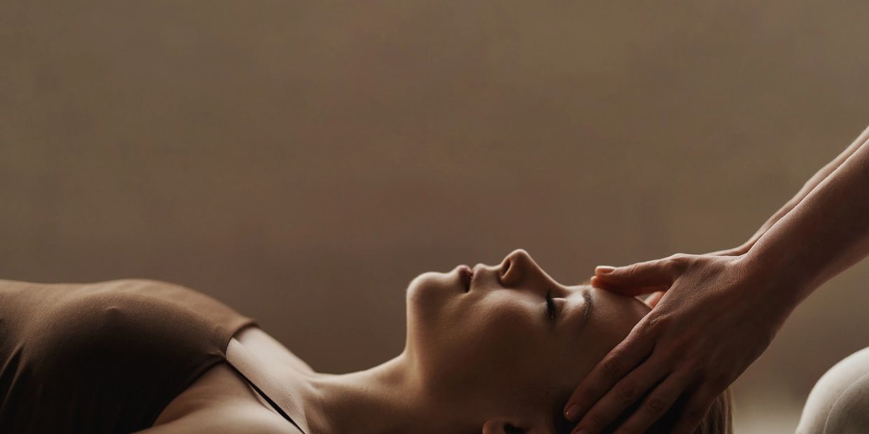 Woman receiving a calming head massage in a serene setting.