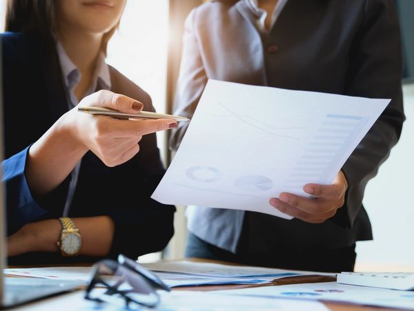 Two professionals discussing tax returns on a document in an office in winnipeg, manitoba