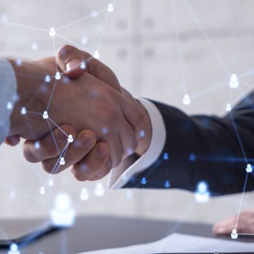 Two business people shaking hands with digital connection symbols.