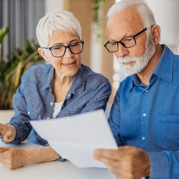 Elderly couple reviewing documents together at home.