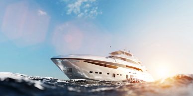 A luxury yacht sailing on the ocean at sunset.