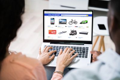 Two people browsing an online shop on a laptop together.