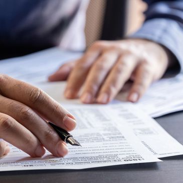 Persona revisando y firmando documentos importantes.