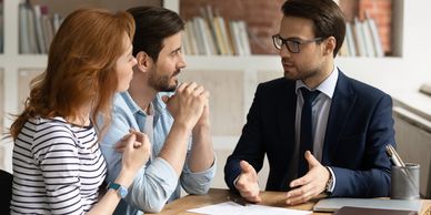 the image is of a couple consulting an attorney for review of a DIY patent application.