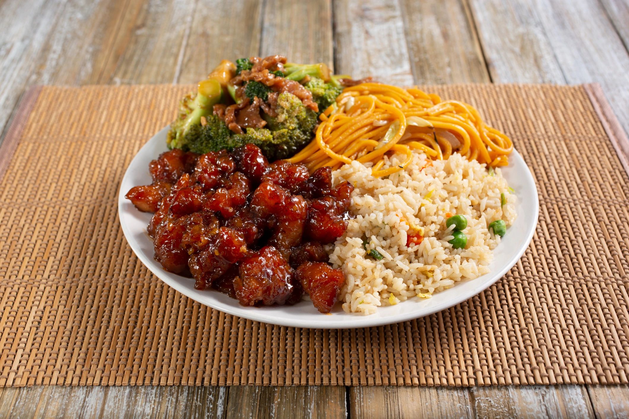 Plate with Chinese food including orange chicken, broccoli, chow mein, and fried rice.
