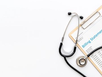 Stethoscope and medical billing statement on clipboard.