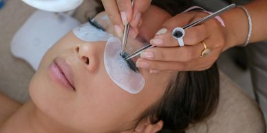 Applying eyelash extensions to a woman.