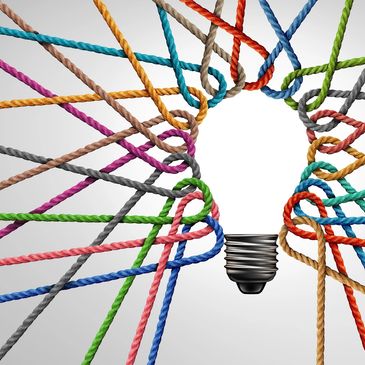 Strings of different colours twist around each other to create an image of a lit light bulb.