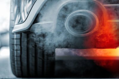 Car exhaust emitting smoke and red heat glow.