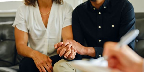 Couple holding hands during a counseling session.