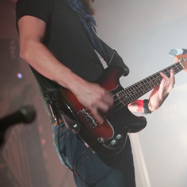 Musician passionately playing an electric guitar on stage.