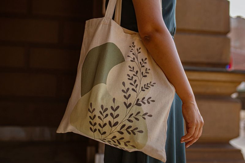 Side view of a young woman, carry the tote bag, with nature design