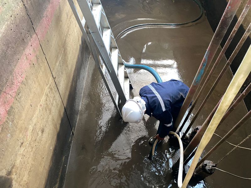 Operators staff protective clothing safely go down to pump wastewater out of the well for disposal.