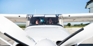 Two people inside a small airplane cockpit.