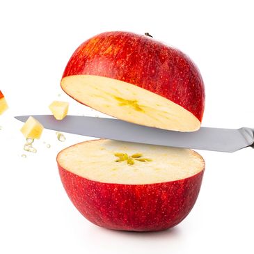 Red apple being sliced with a knife, showing fresh juicy interior.