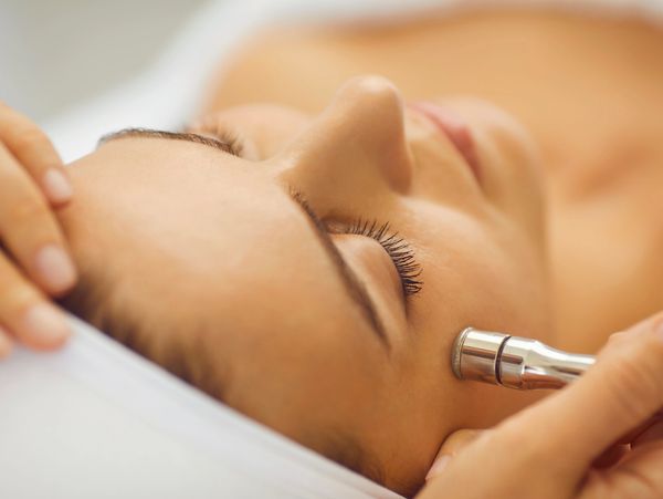 Close-up of a woman receiving a microdermabrasion treatment.