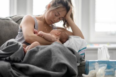 Mother breastfeeding her baby on a couch.