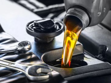 Engine oil being poured into a car engine.