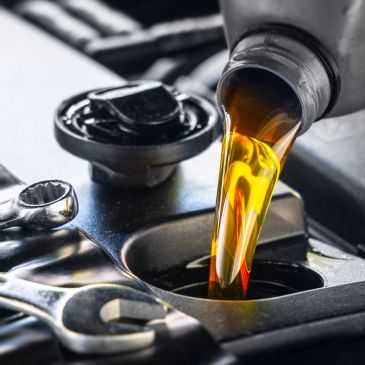 Engine oil being poured into a car engine.