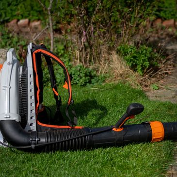 A leaf blower resting on a well-maintained lawn, ready to tackle any outdoor cleanup with ease.