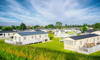 A scenic view of a mobile home park under a bright blue sky.
