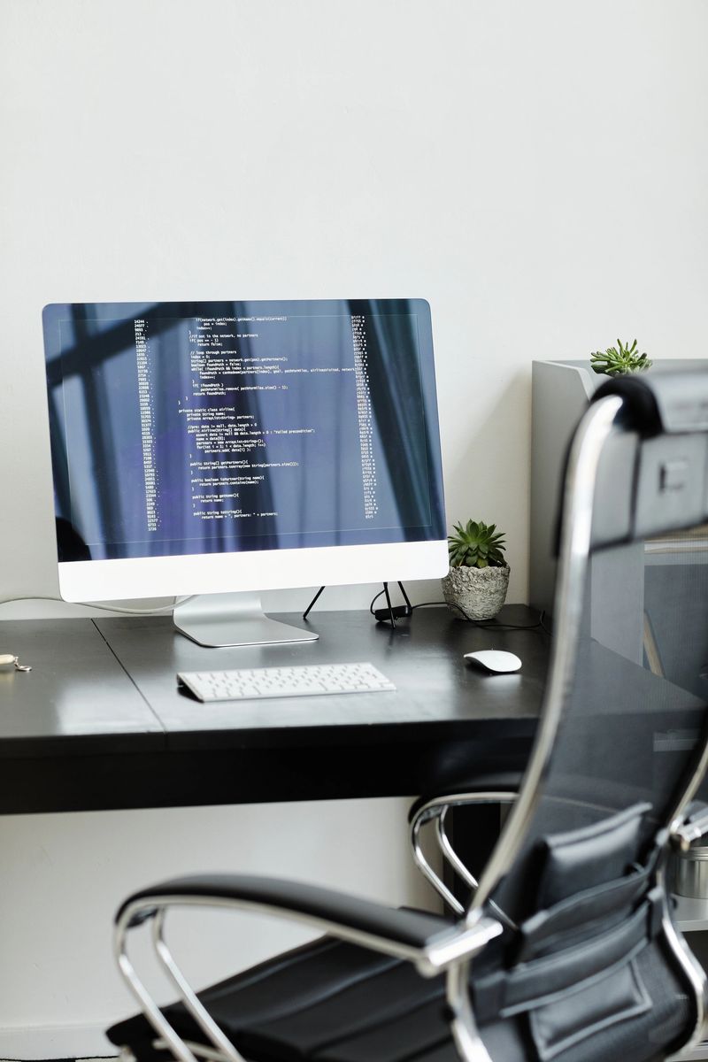 Image of computer monitor with software standing on the table at modern office