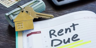 Keys and cash with a rent due reminder.