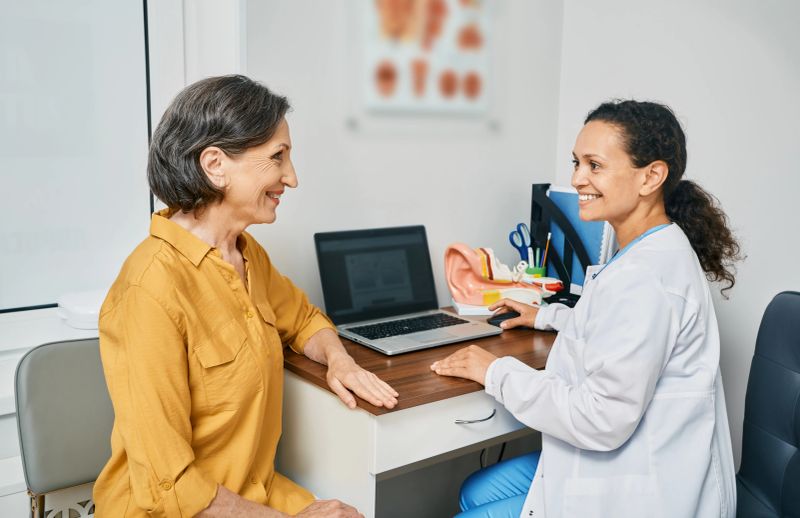 Consultation with experienced female audiologist to mature woman patient at medical clinic. Treatment of hearing loss in senior people
