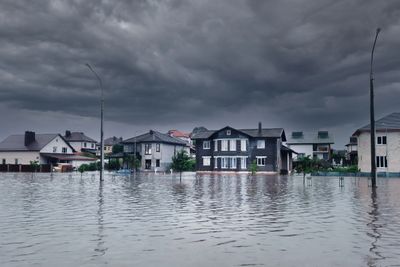 Flooded residential area under dark, stormy skies.