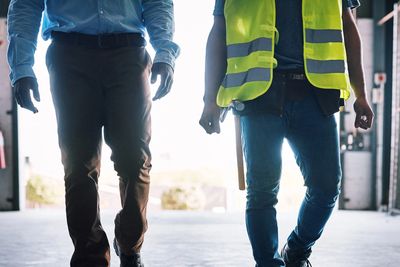 Two workers walking in an industrial warehouse.