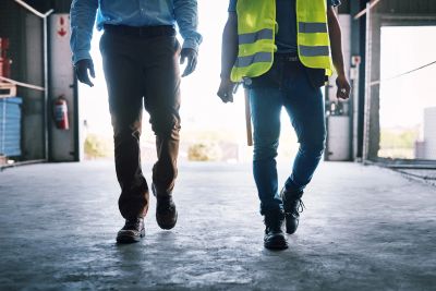 Two workers walking in a construction site.