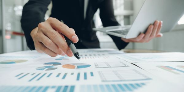 Businessman analyzing charts and graphs with a laptop.