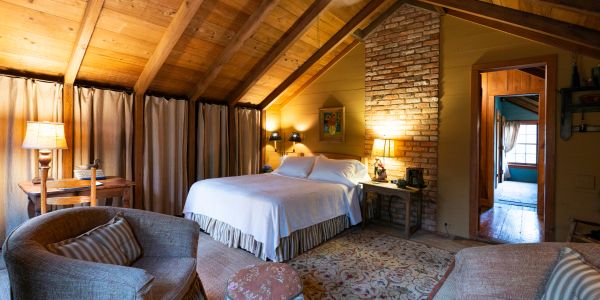 Cozy attic bedroom with rustic decor and warm lighting.