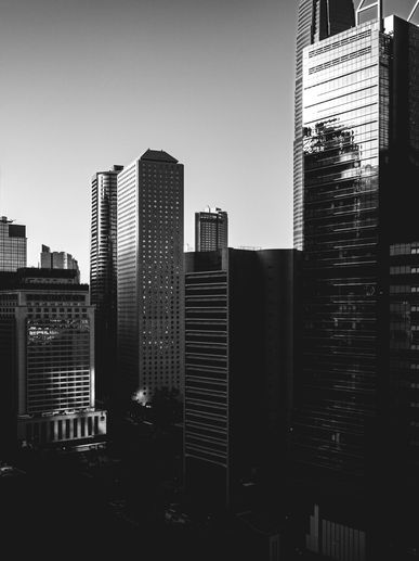 Black and white photo of modern city skyscrapers during daylight.
