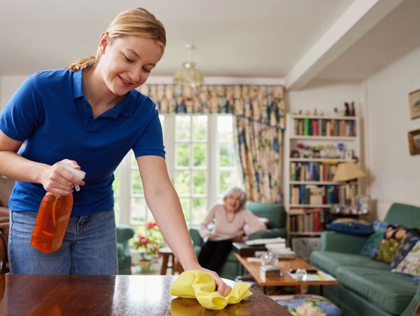 woman cleaning table in living room