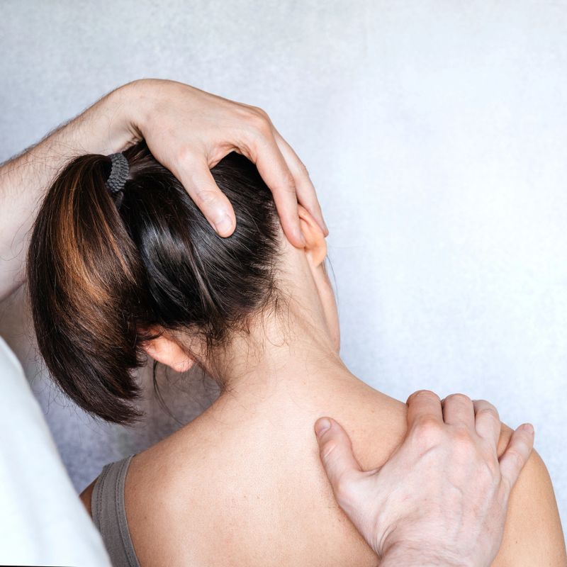 A chiropractor performing a manipulation on woman's neck and administering of spinal adjustments to relive neck pain