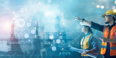 Engineers planning with digital interface in industrial setting.