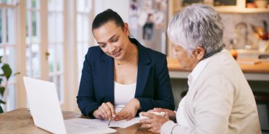 Two women discussing documents at a table.