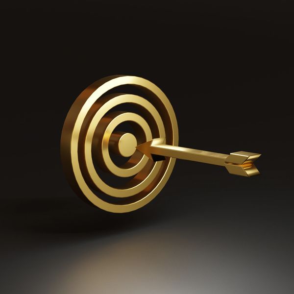 Golden arrow hitting the center of a golden target.