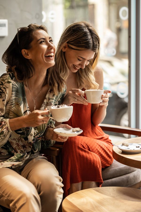 Friends Laughing Together Over Coffee