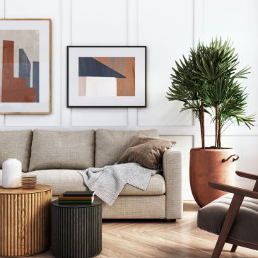 Modern living room with beige sofa and green plant.