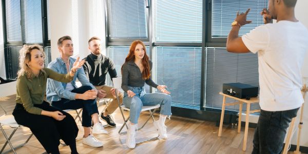 Group playing charades with gestures indoors.