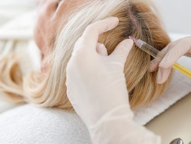 Doctor injecting scalp of a person for hair treatment.