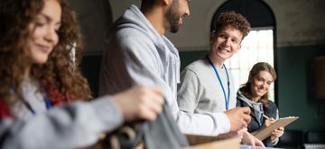 Young professionals engaged in a collaborative meeting with smiles and note-taking.