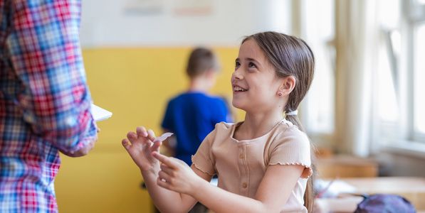 A girl engaging in a social activity in a classroom.