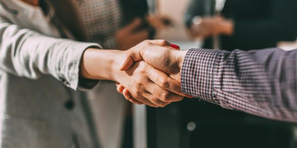 Close-up of a handshake between two people in a professional setting.