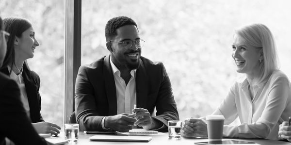 Five professionals engaged in a lively business meeting with smiles and discussions over a flat fee listing on MLS.  He is saving on his FSBO listing with MLS exposure. 